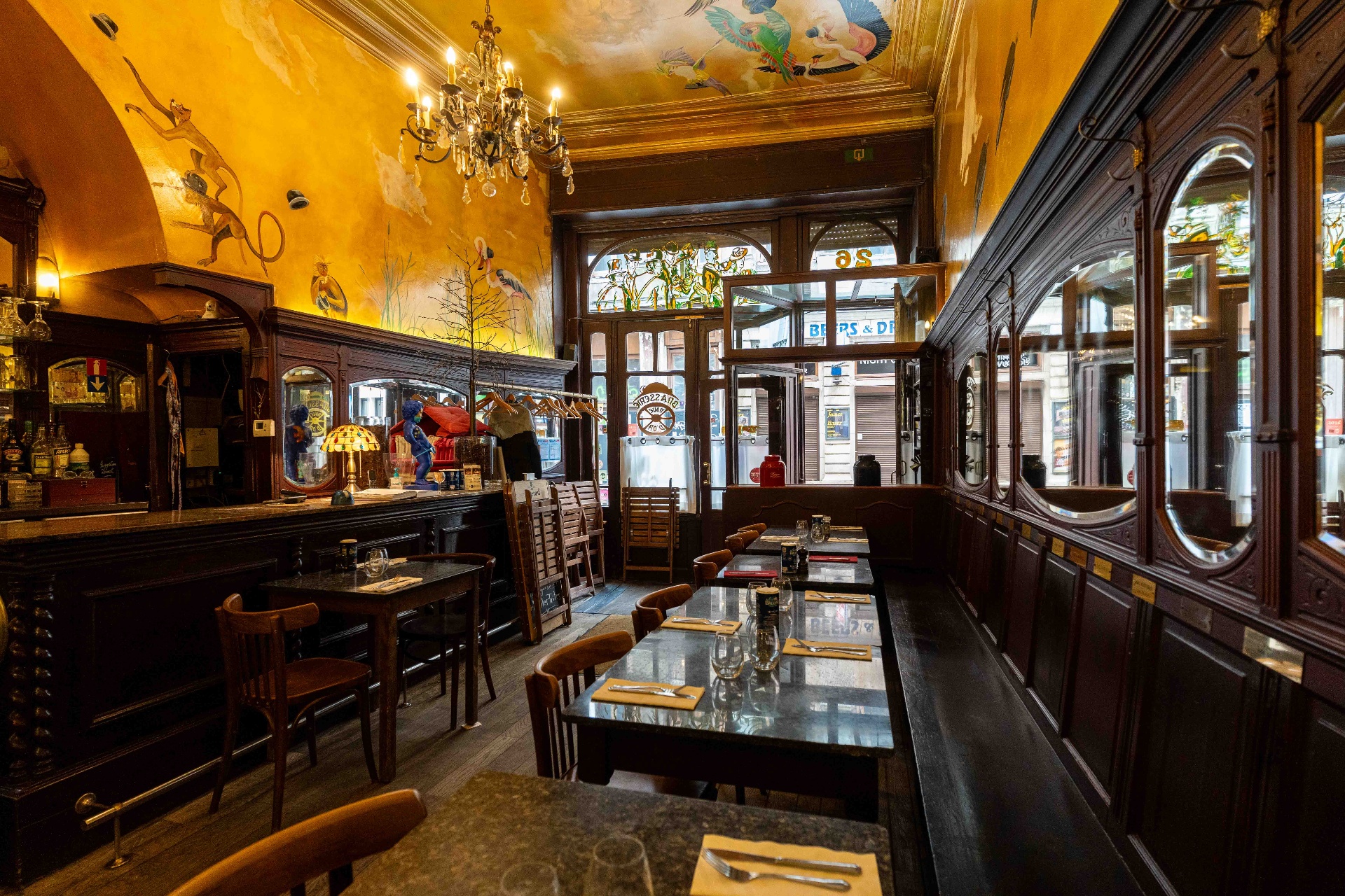L'entrée de la brasserie avec banquettes, miroirs ovales et plafond peint