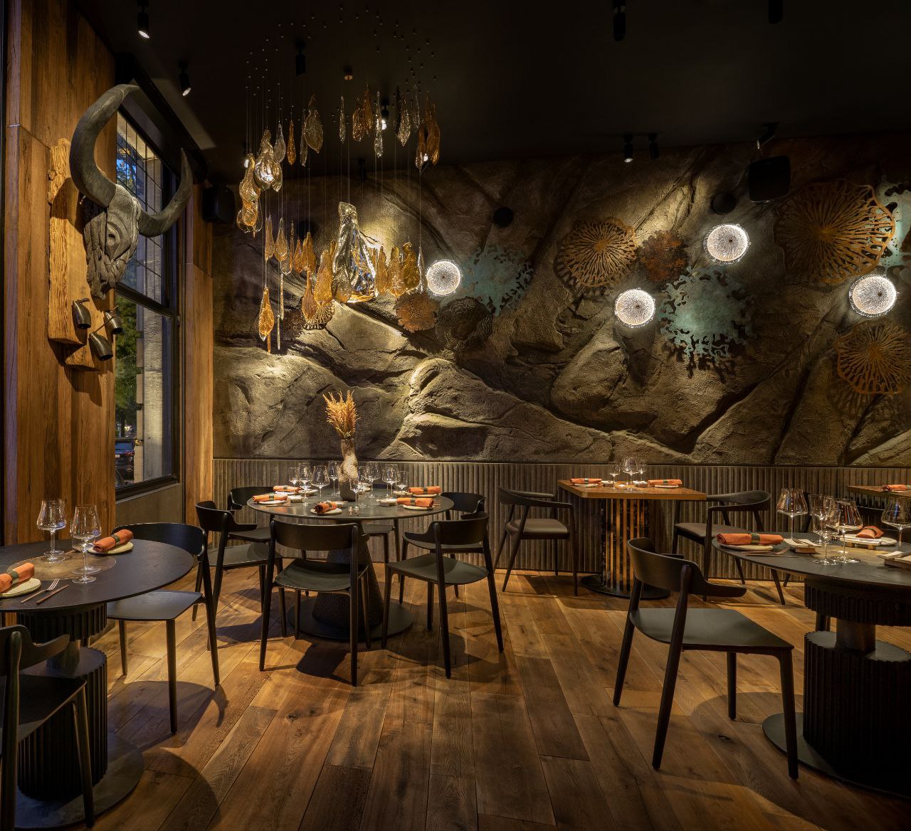 Salle de Molfar avec mur en roche sculptée et suspensions en verre soufflé