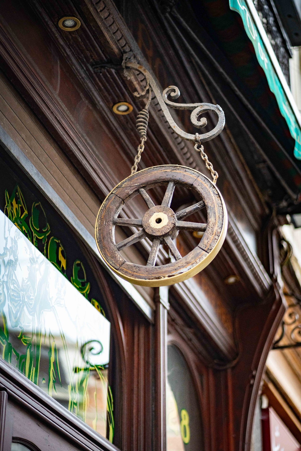 La roue dorée suspendue à la façade de La Roue d'Or, rue des Chapeliers