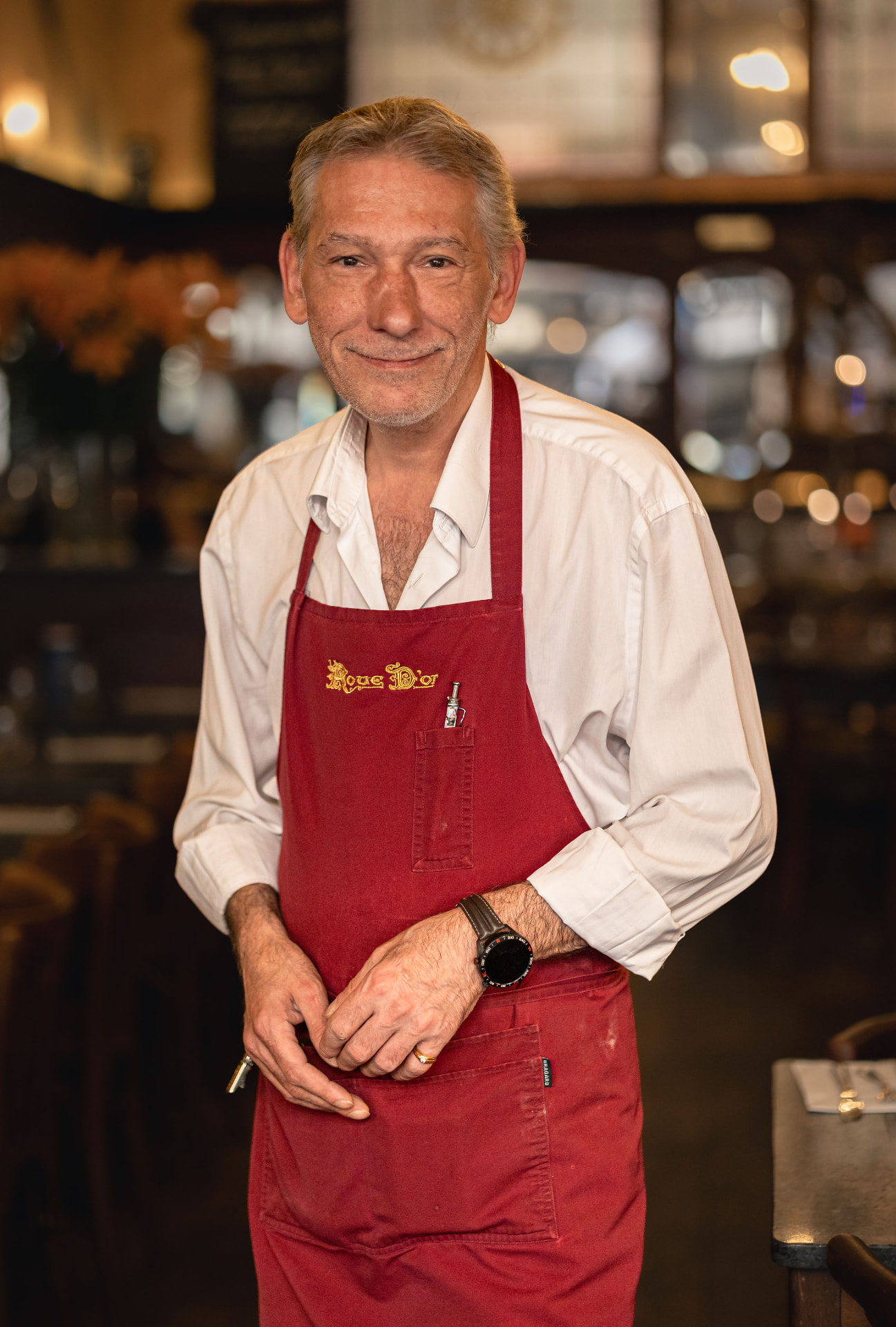 Yves, chef de rang à La Roue d'Or, dans son tablier rouge brodé