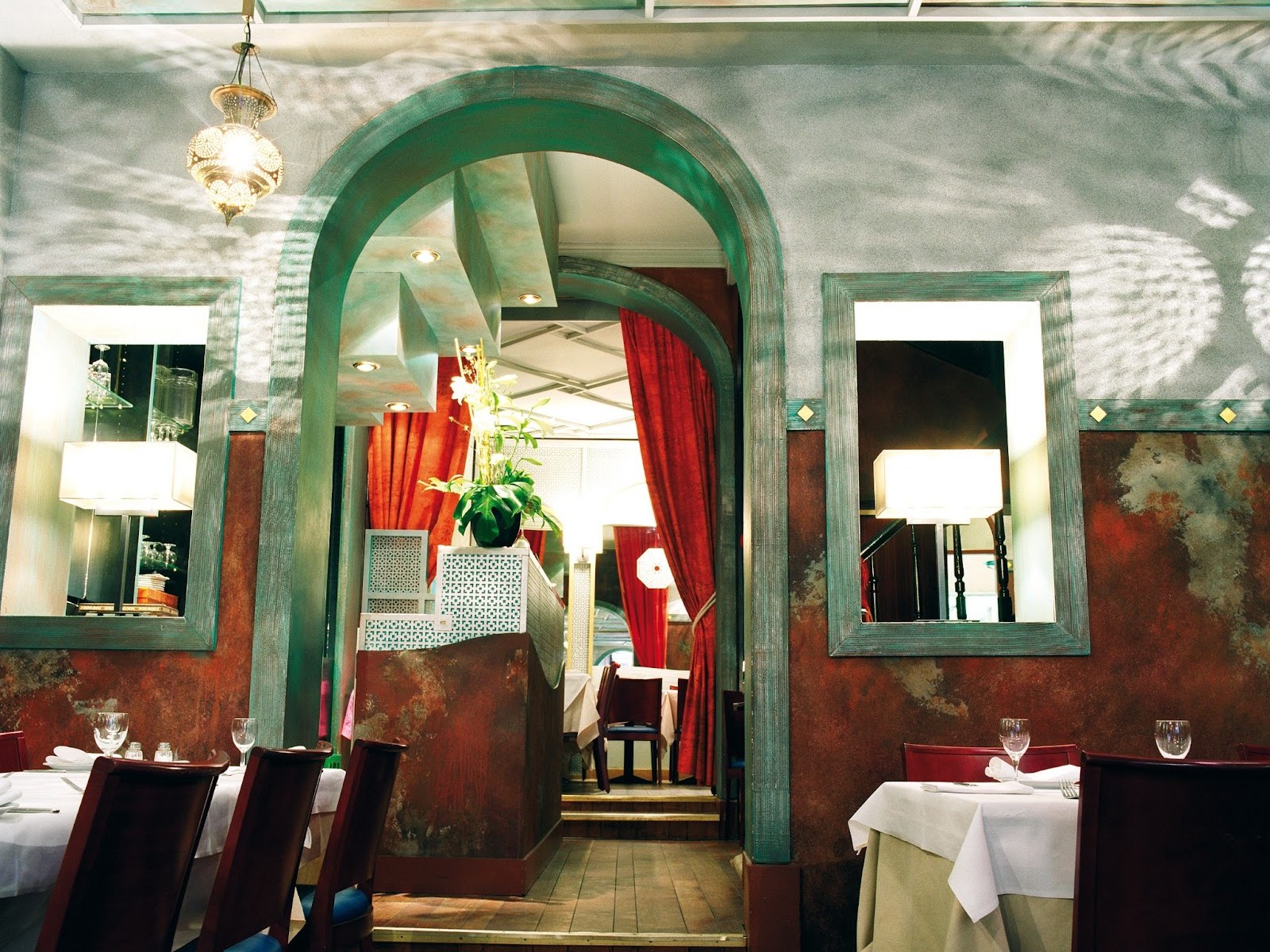 Salle du restaurant libanais Al Barmaki à Bruxelles, arches patinées et lanternes orientales