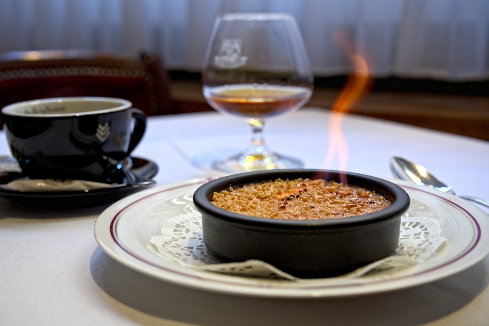 Dessert flambé servi avec un digestif chez Aux Armes de Bruxelles