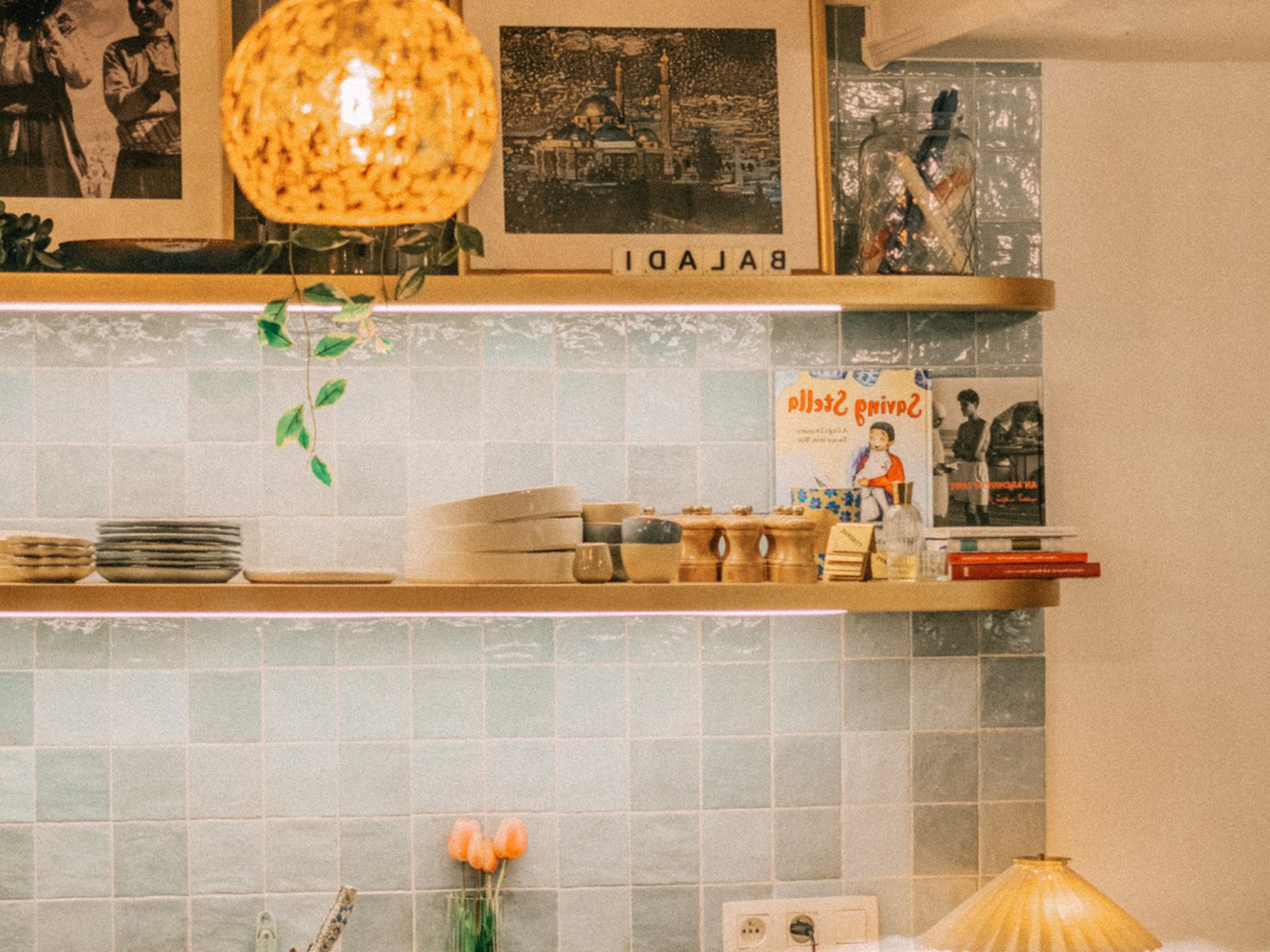 Décor du restaurant Baladi : étagères, céramiques, cadres et faïence verte au mur