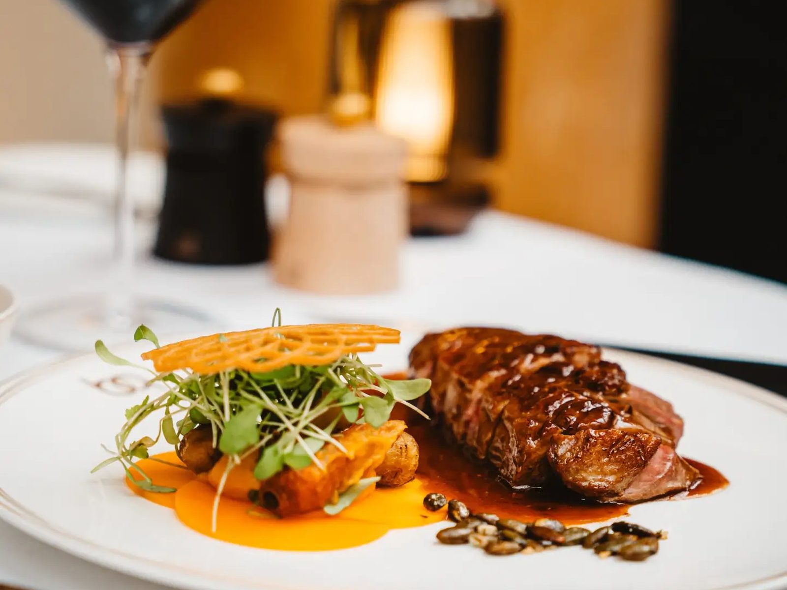 Pièce de viande sauce et garniture dressée dans une assiette du Belga Queen