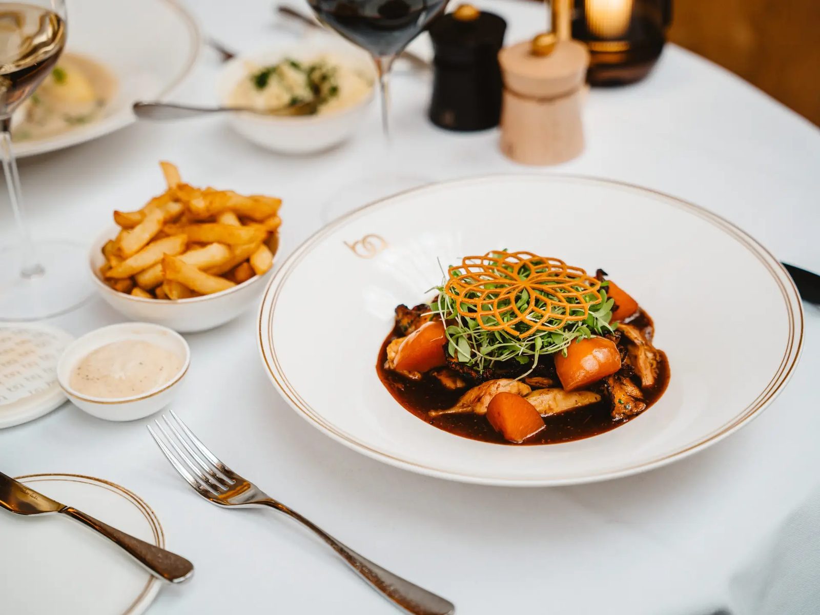 Plat mijoté en sauce brune servi avec des frites belges au Belga Queen