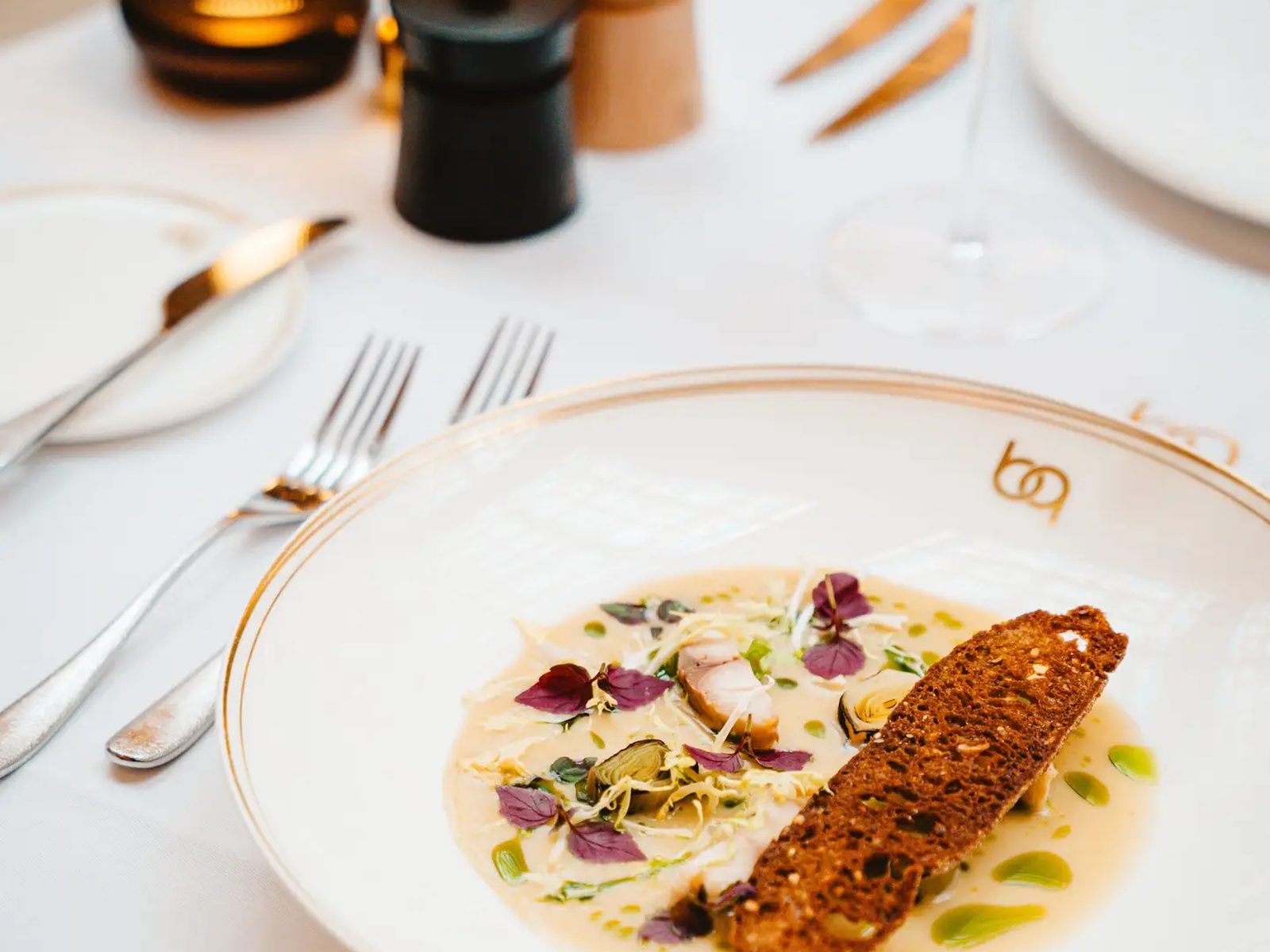 Filet de poisson à la peau croustillante dressé dans une assiette du Belga Queen
