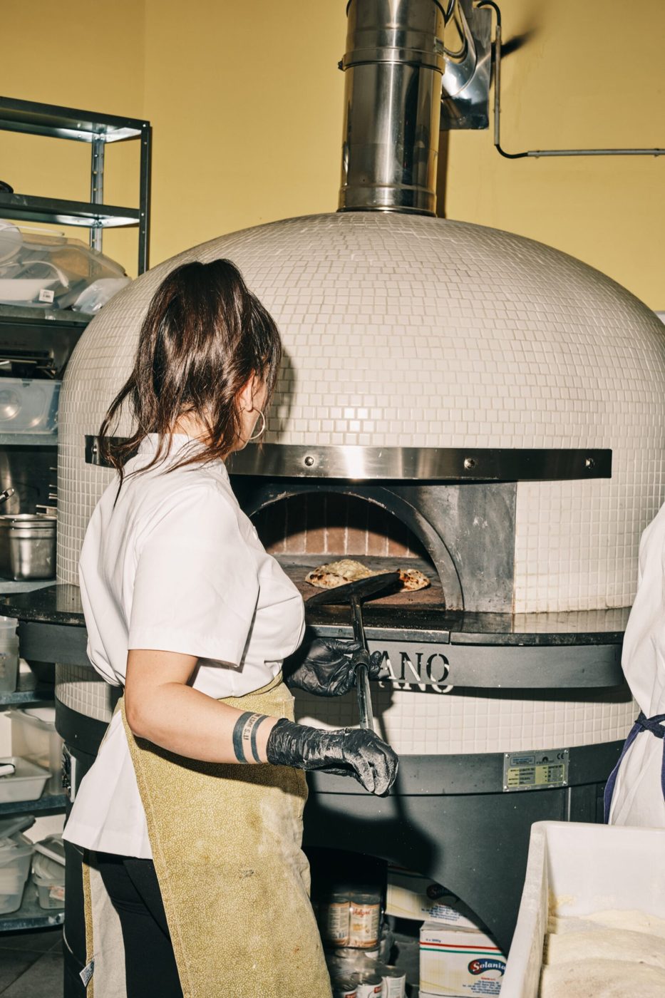 Pizzaiola devant le four à bois de la pizzeria Biga, place Colignon