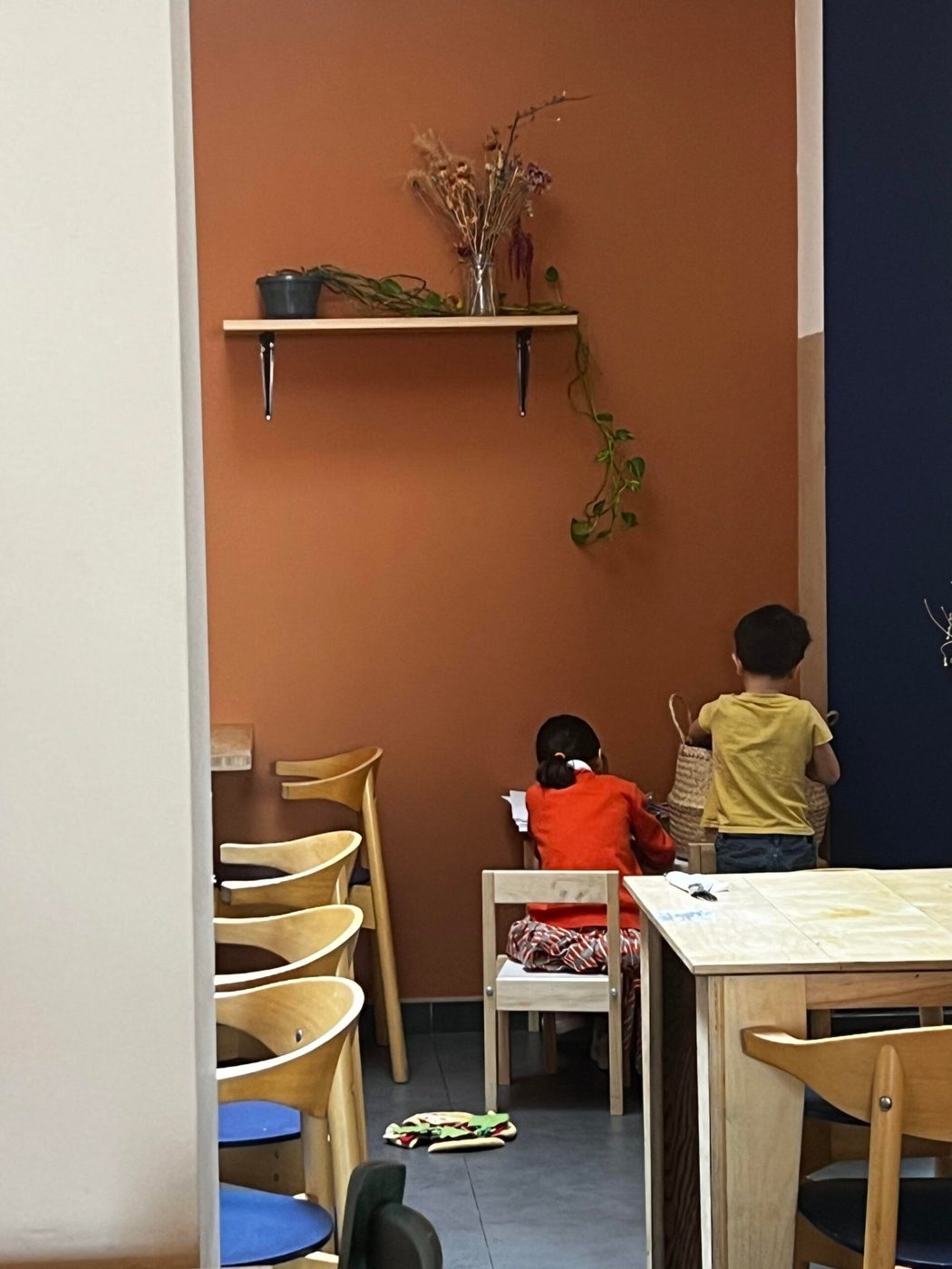Salle de la pizzeria Biga aux murs terracotta avec tables en bois