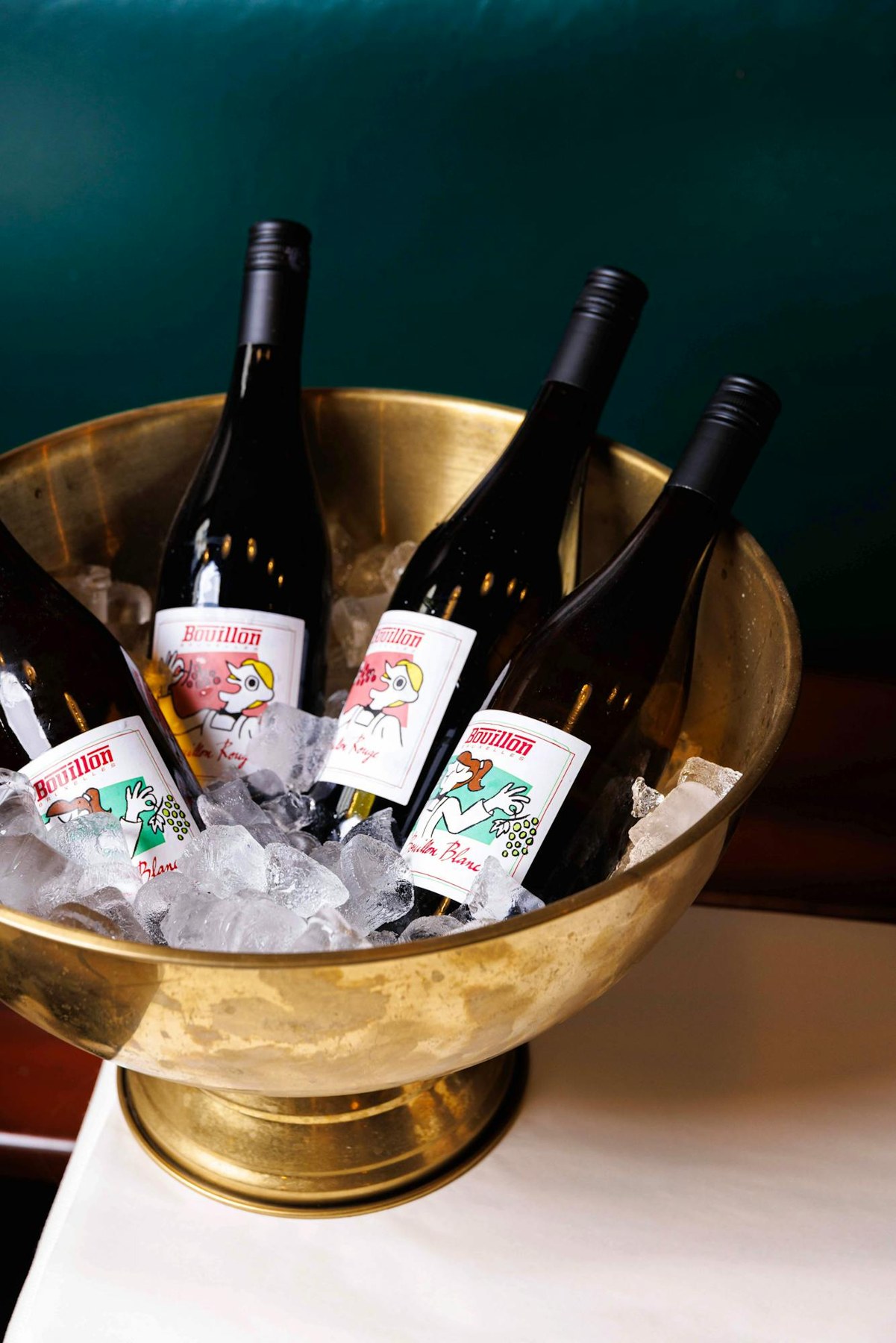 Bouteilles de vin étiquetées Bouillon dans un seau à glace en laiton