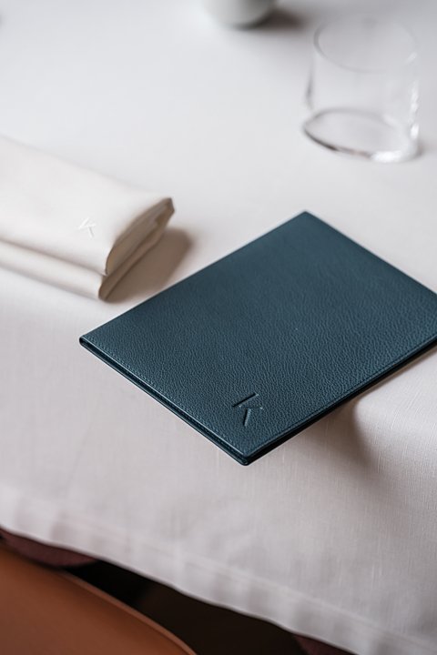 Carte du Bozar Restaurant reliée en cuir posée sur une nappe blanche