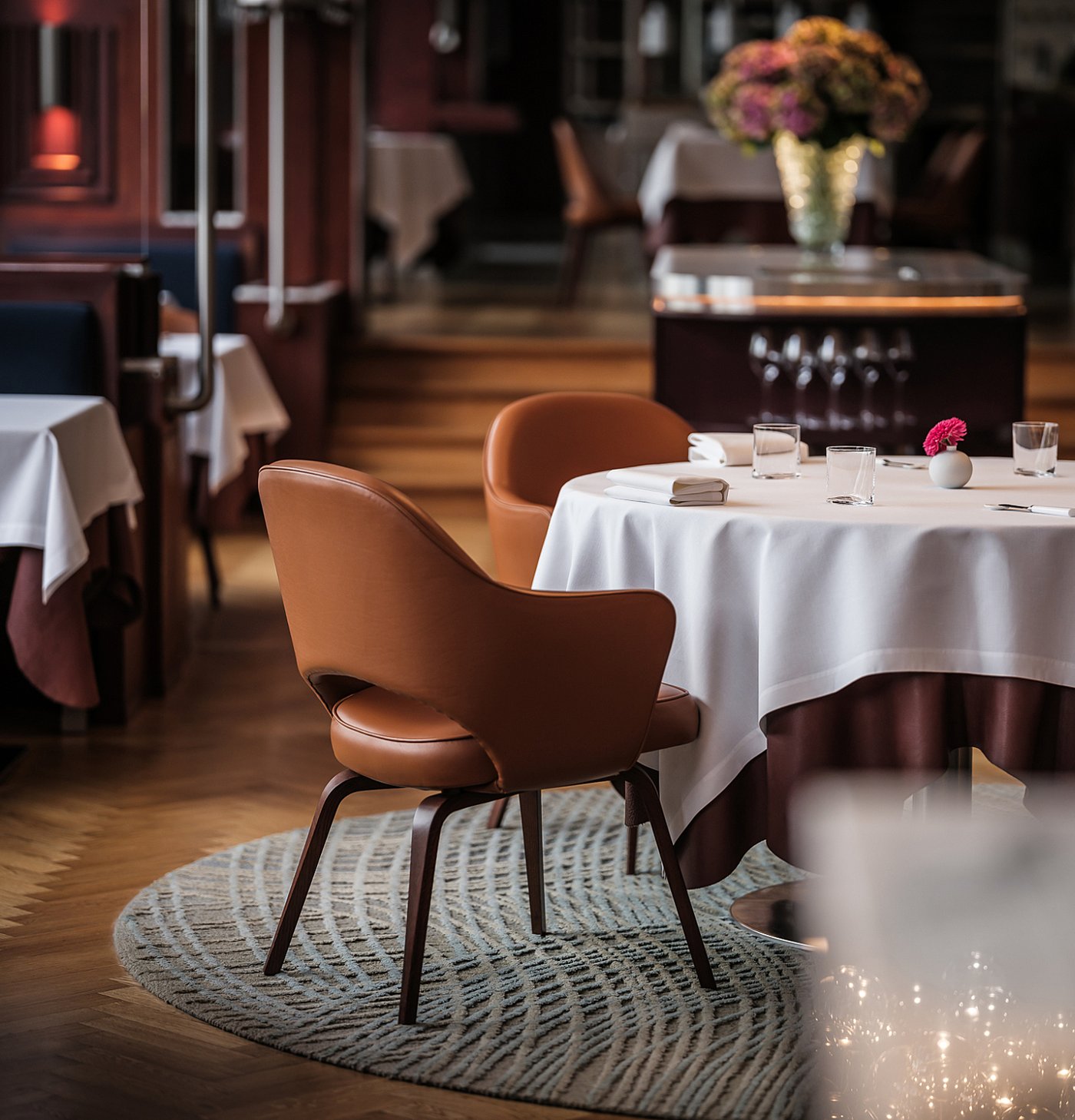 Salle du Bozar Restaurant avec fauteuils cognac, nappes blanches et boiseries