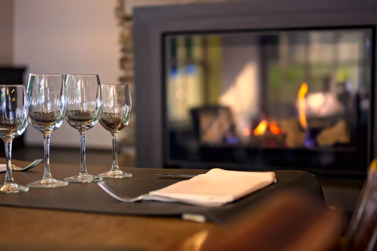 Verres de vin posés devant le feu ouvert de la Brasserie de la Patinoire