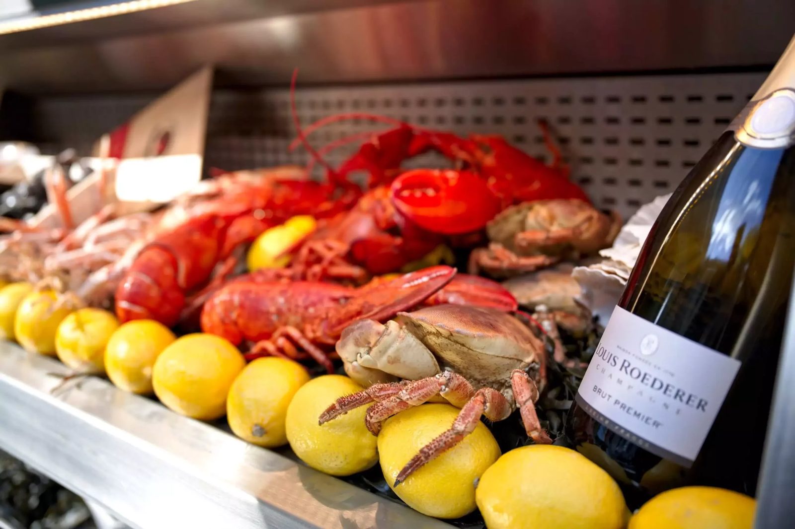 Homards et crustacés présentés sur l'étal glacé de l'écailler de la Patinoire