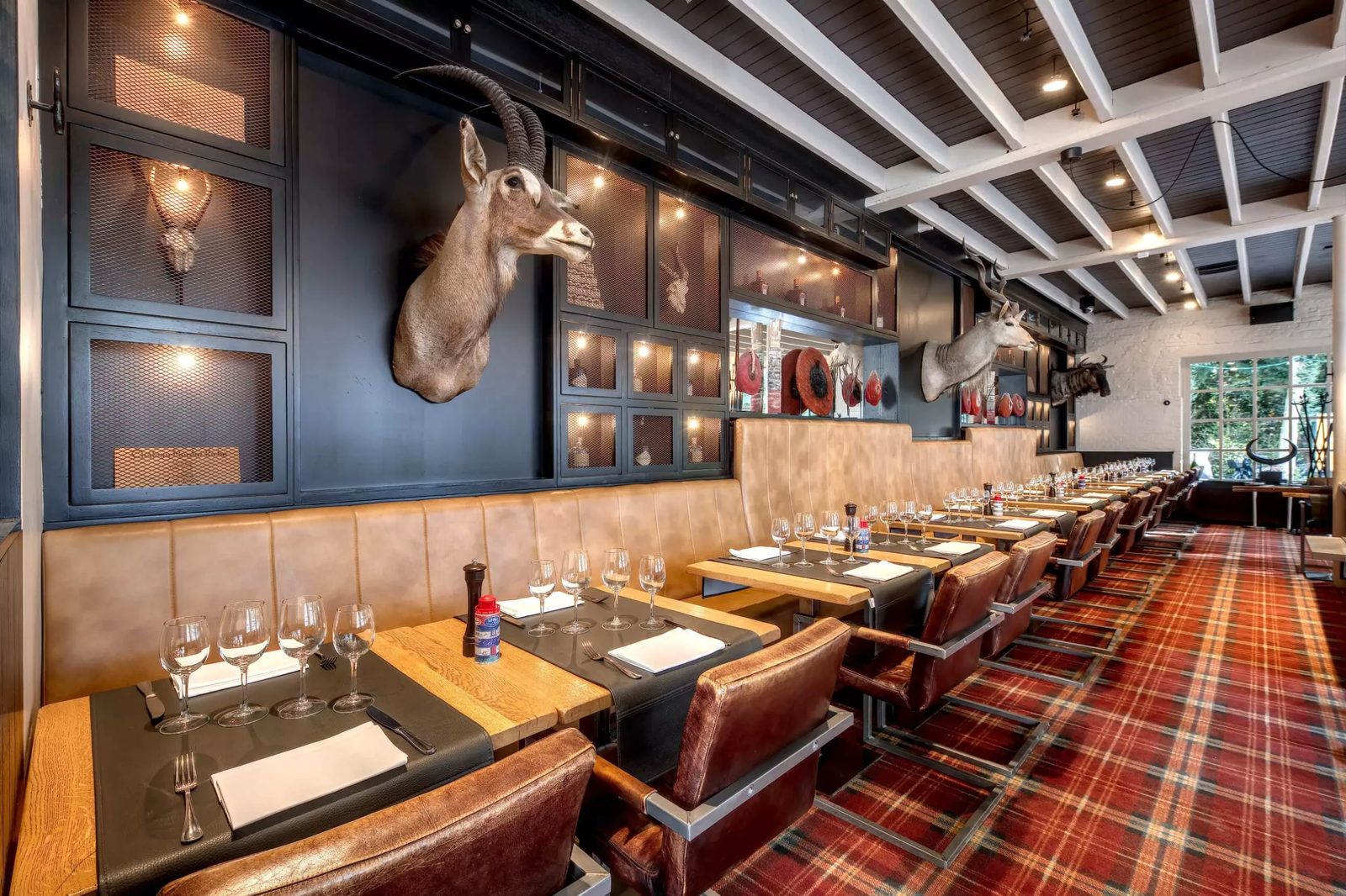 Salle intérieure de la Brasserie de la Patinoire avec sol tartan et banquettes de cuir