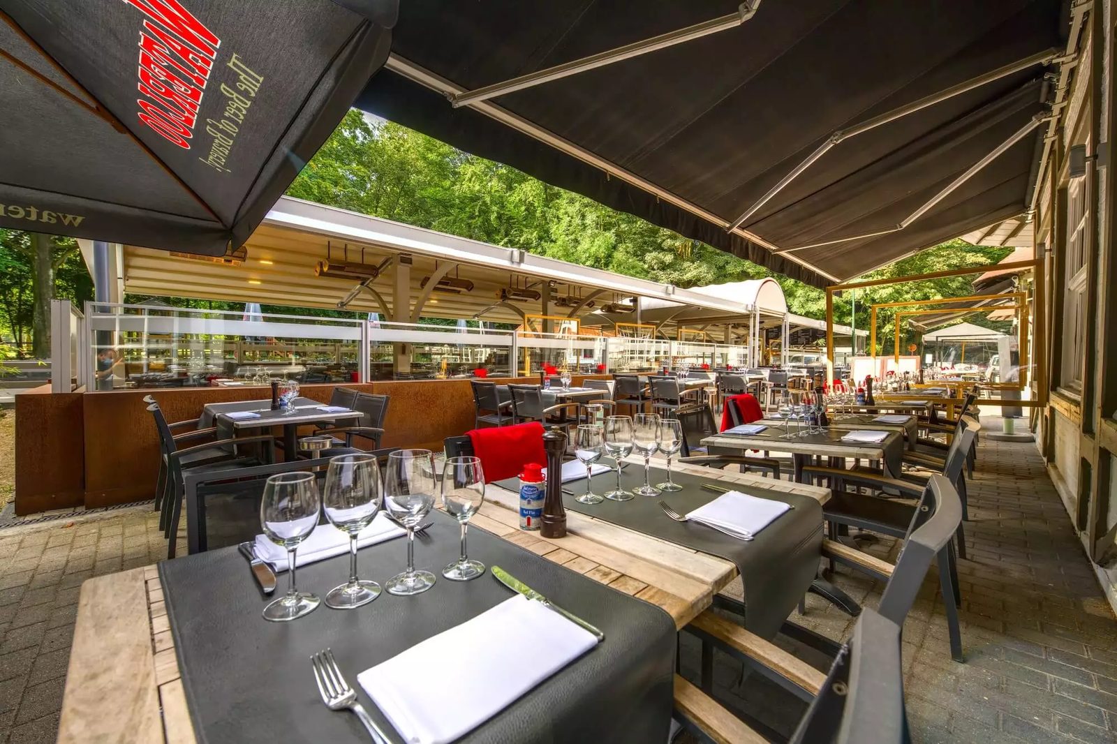Terrasse ombragée de la Brasserie de la Patinoire sous les arbres du Bois de la Cambre