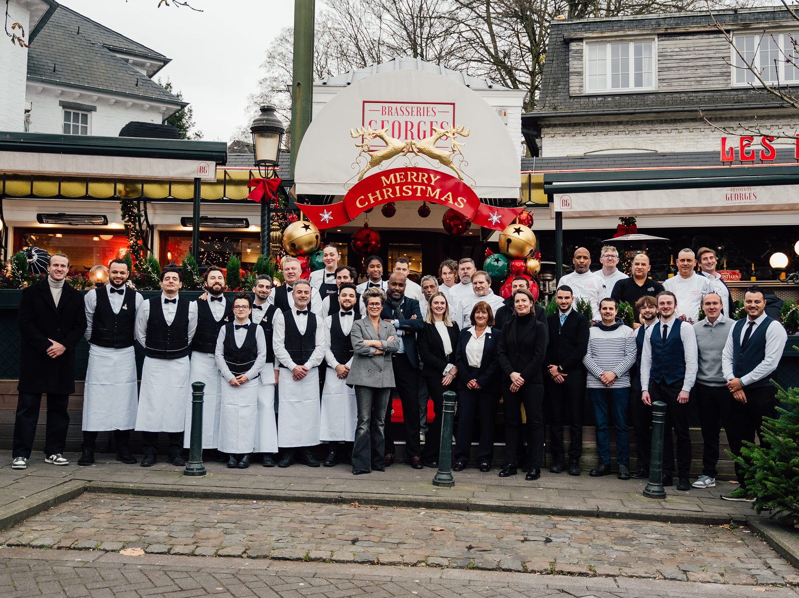 Toute l'équipe des Brasseries Georges réunie devant la façade du restaurant