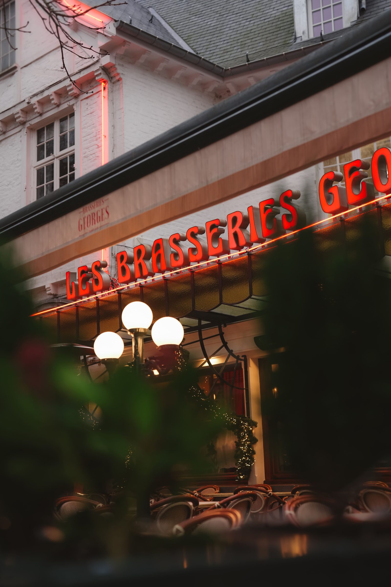 Enseigne lumineuse rouge Les Brasseries Georges à la tombée du jour