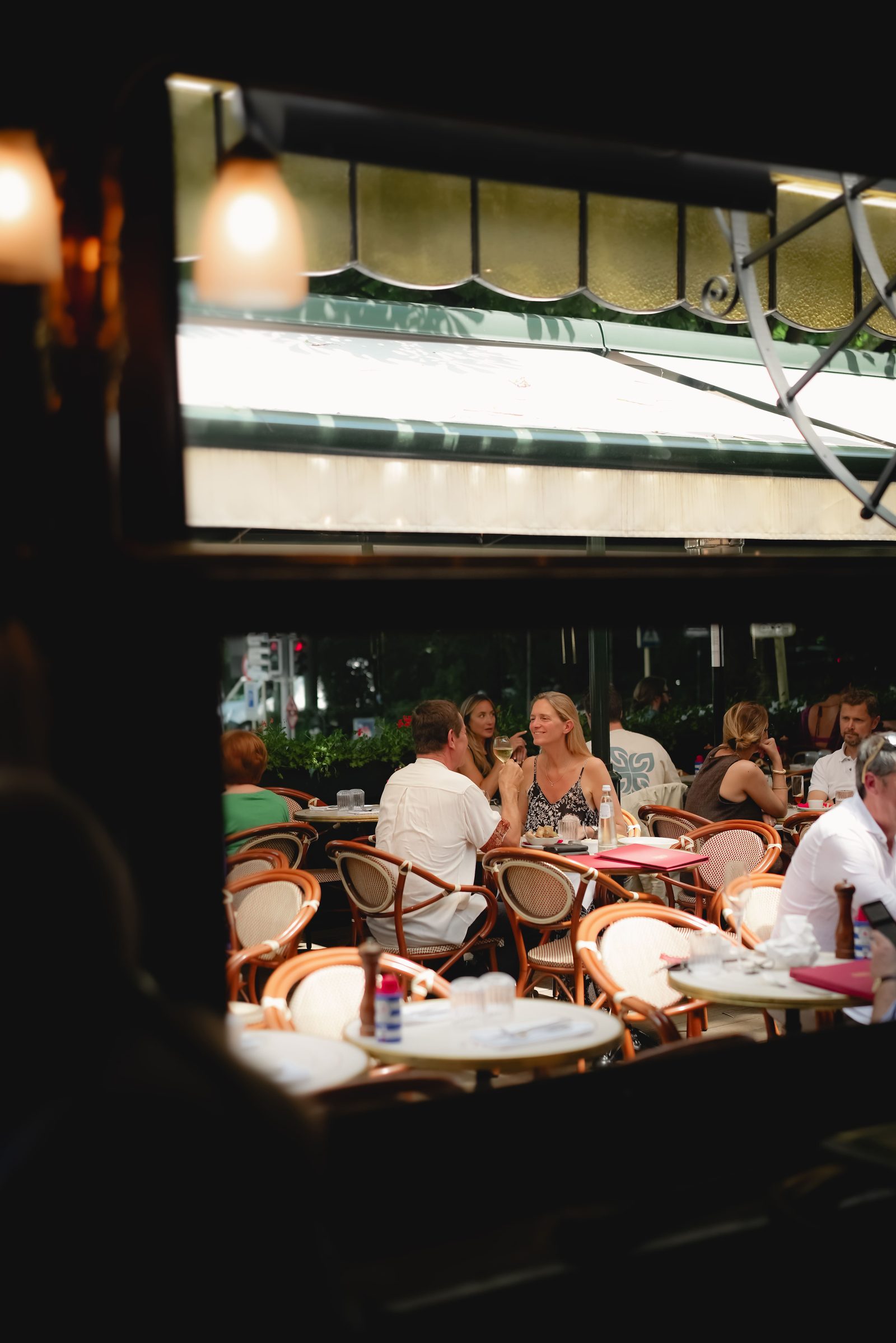 Salle animée des Brasseries Georges en soirée vue de la rue