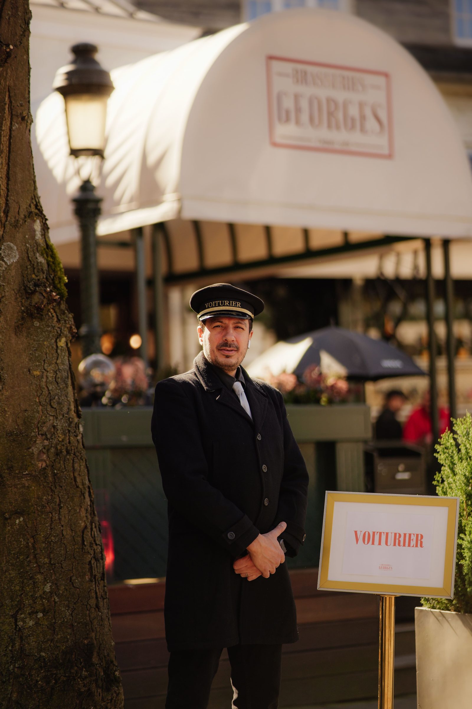Voiturier des Brasseries Georges devant l'entrée du restaurant