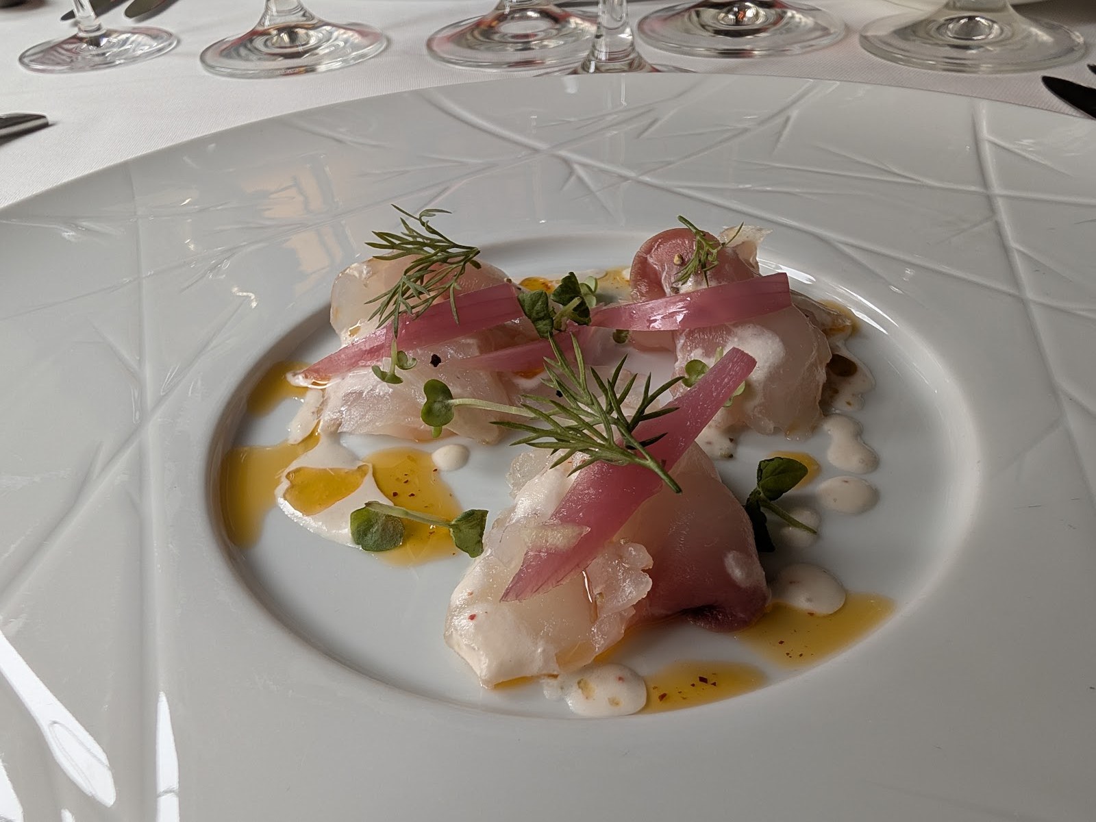 Assiette de poisson cru dressée finement au restaurant gastronomique Brugmann
