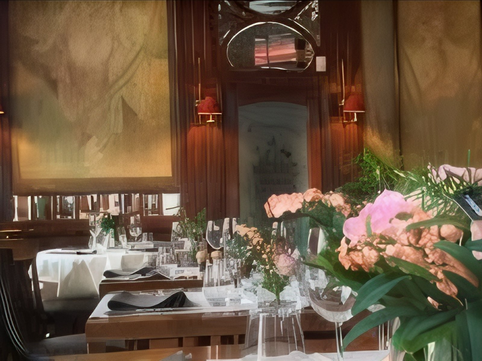 Tables dressées avec nappes blanches et bouquets de fleurs au restaurant italien Buca di Bacco