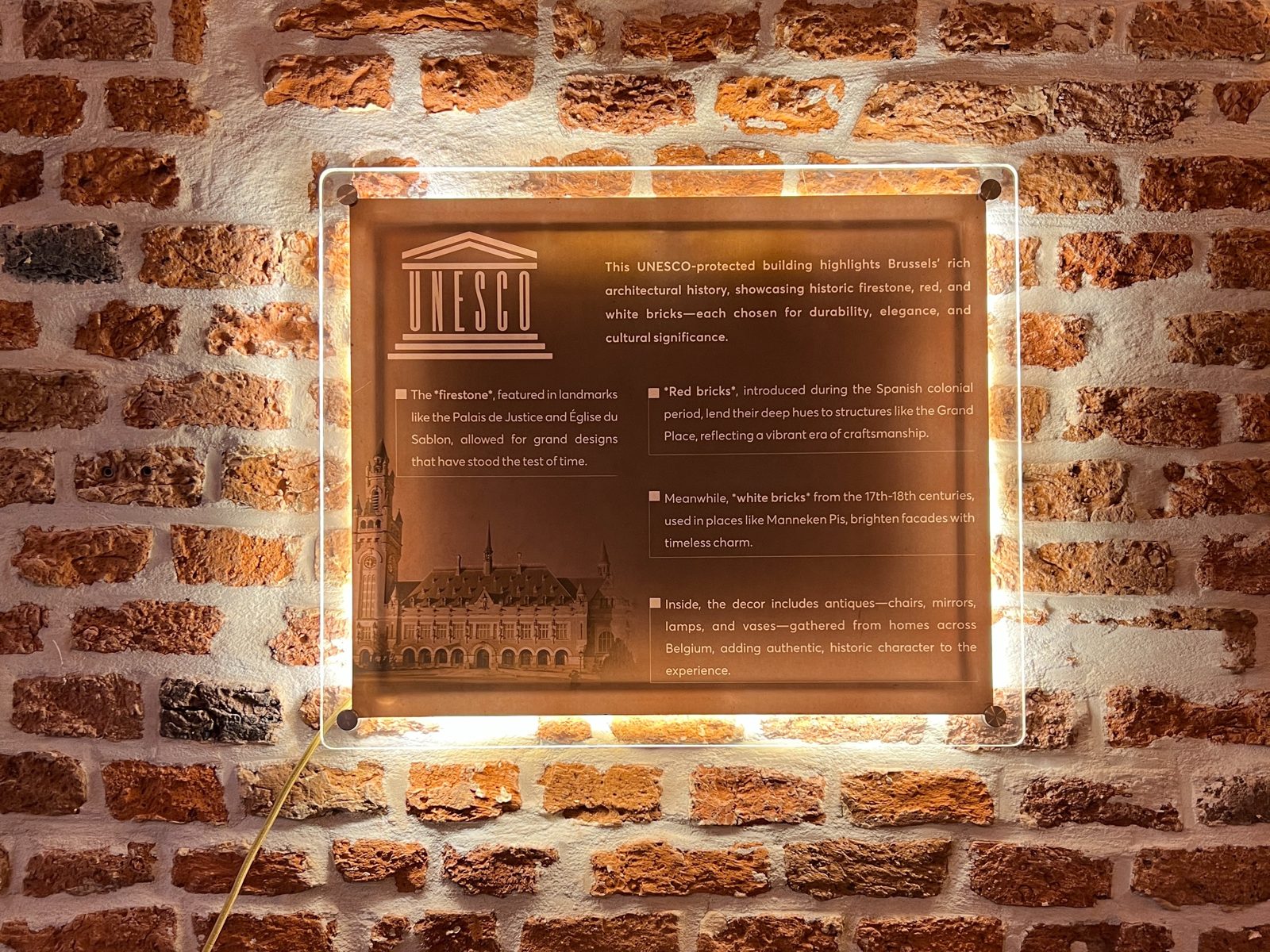 Plaque UNESCO sur le mur de briques de Celi's Resto