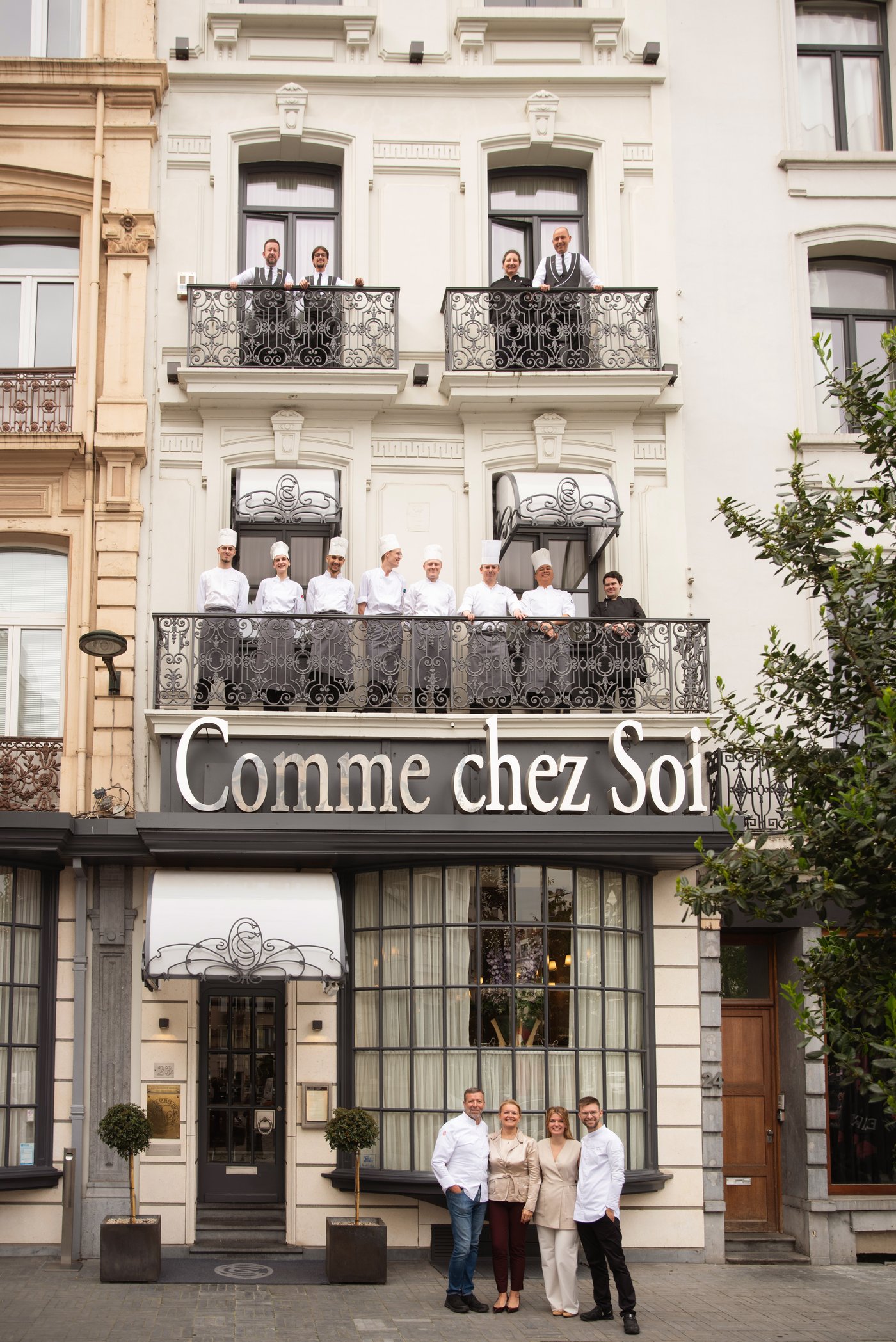 Façade blanche du Comme chez Soi place Rouppe avec la brigade aux balcons