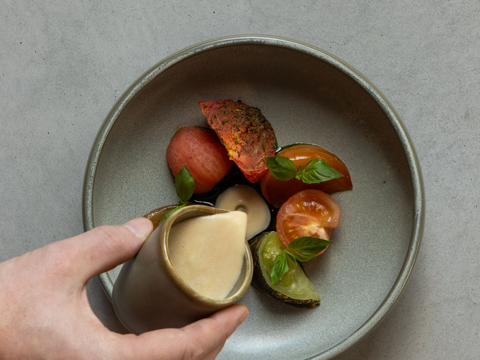 Plat de tomates et basilic avec sauce servie à part chez Correspondance