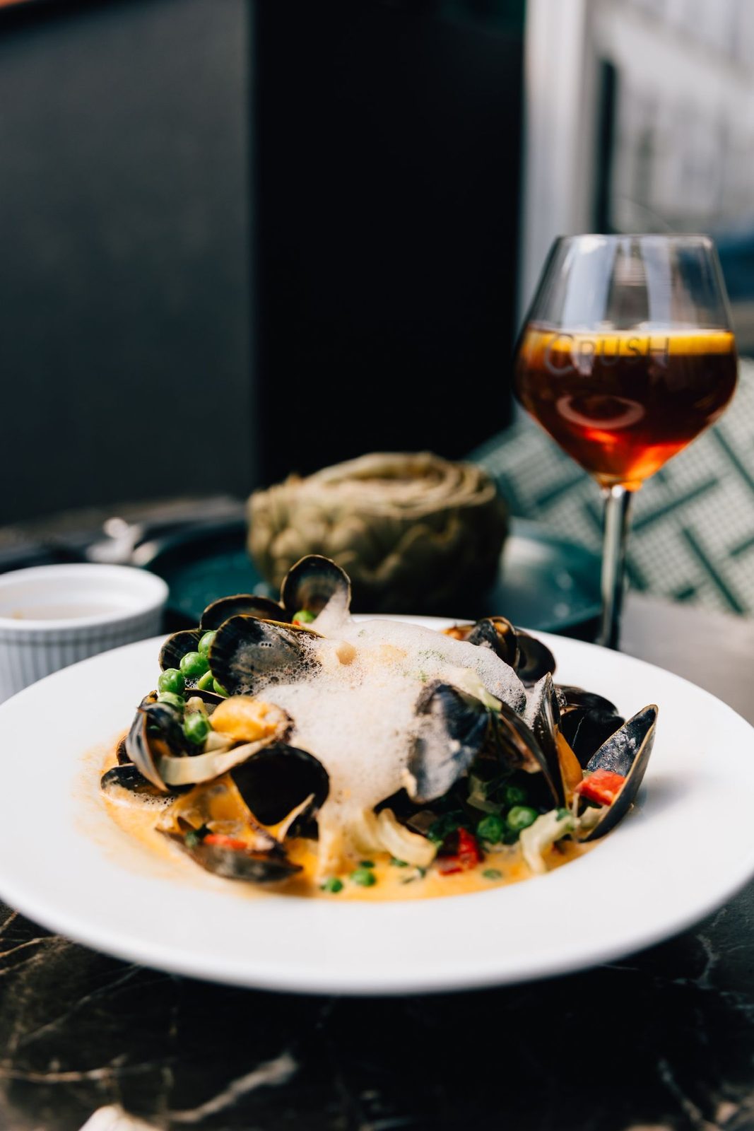 Assiette de moules gratinées et verre de vin rouge chez Crush