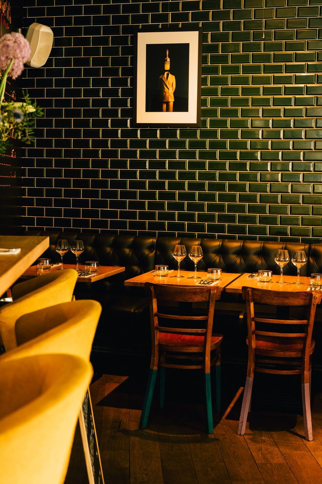 Salle de Crush avec murs de carrelage vert émeraude et banquettes jaunes