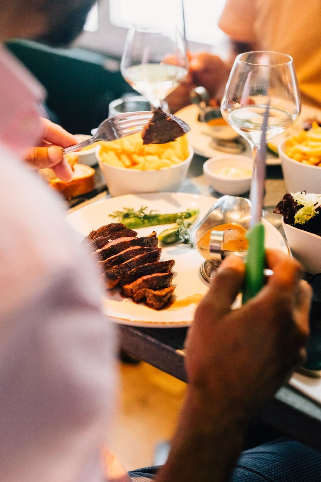 Table dressée avec plats à partager et frites chez Crush