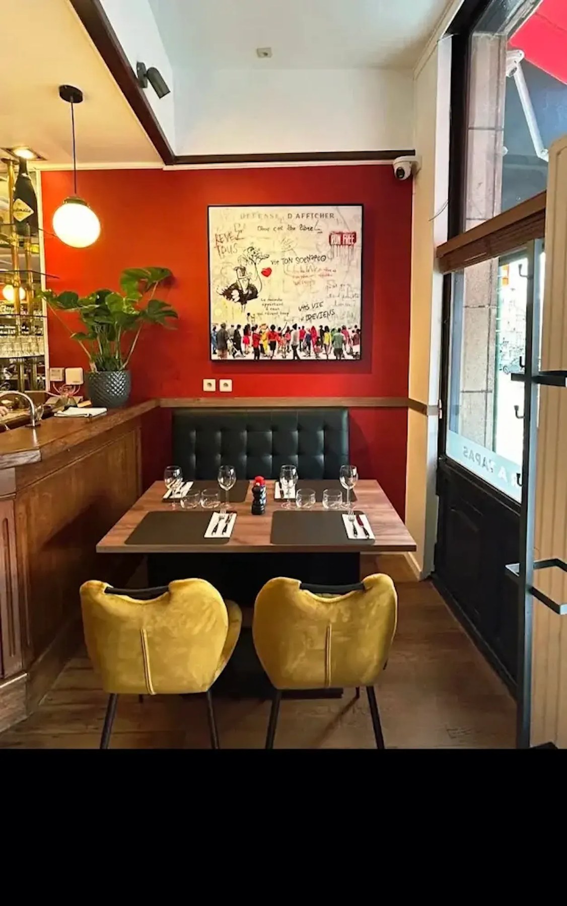 Table dressée près de la vitrine avec fauteuils jaunes chez L'Entrée des Artistes