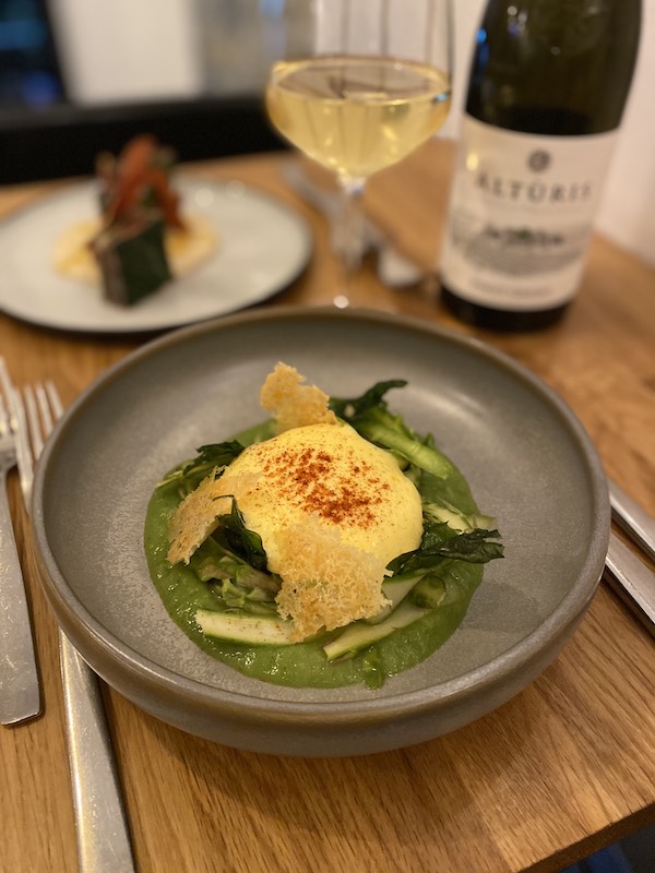 Plat d'asperges sauce mousseline et verre de vin blanc au Jardin des Olives