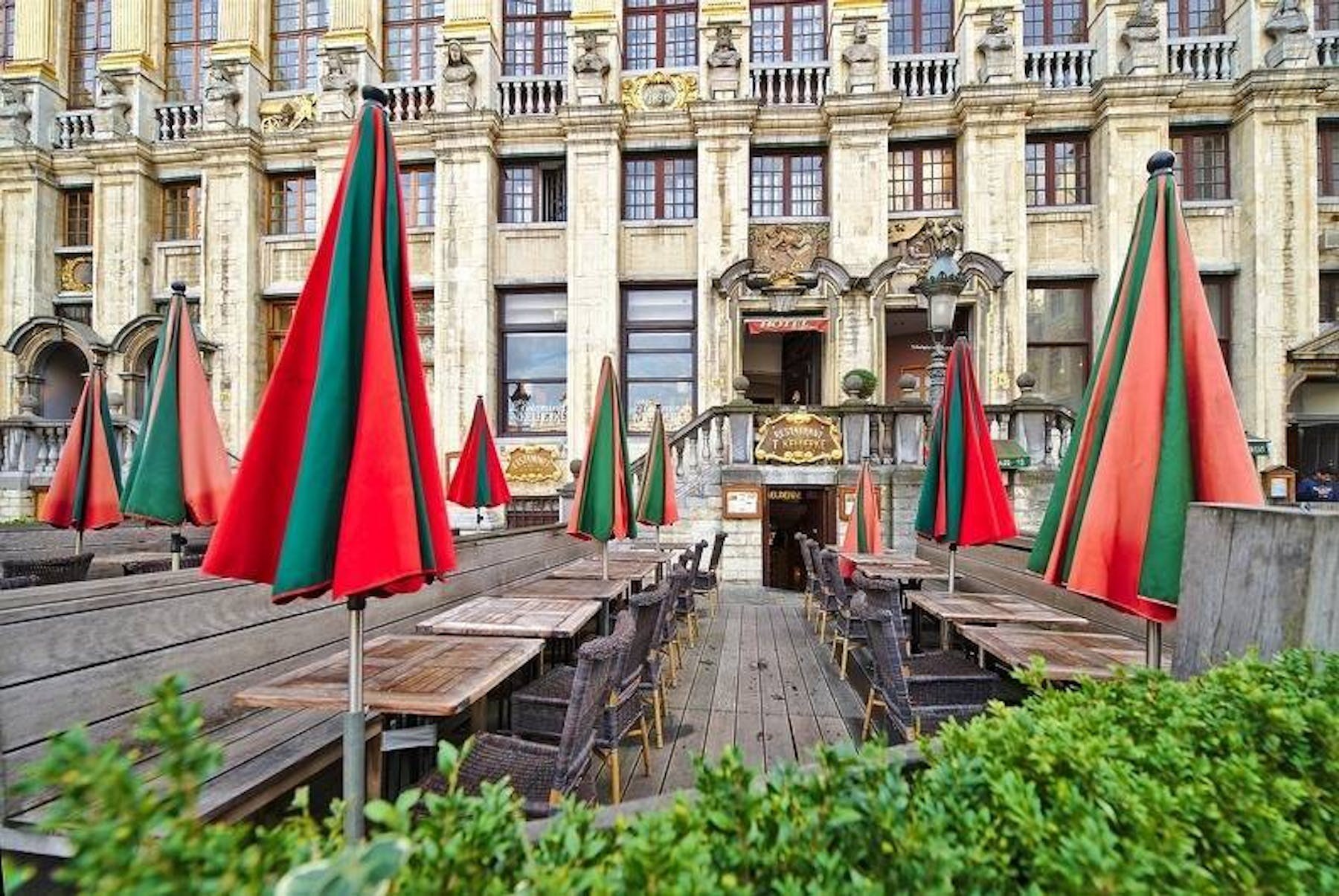 Terrasse du 't Kelderke sur la Grand-Place de Bruxelles, parasols rouges et verts