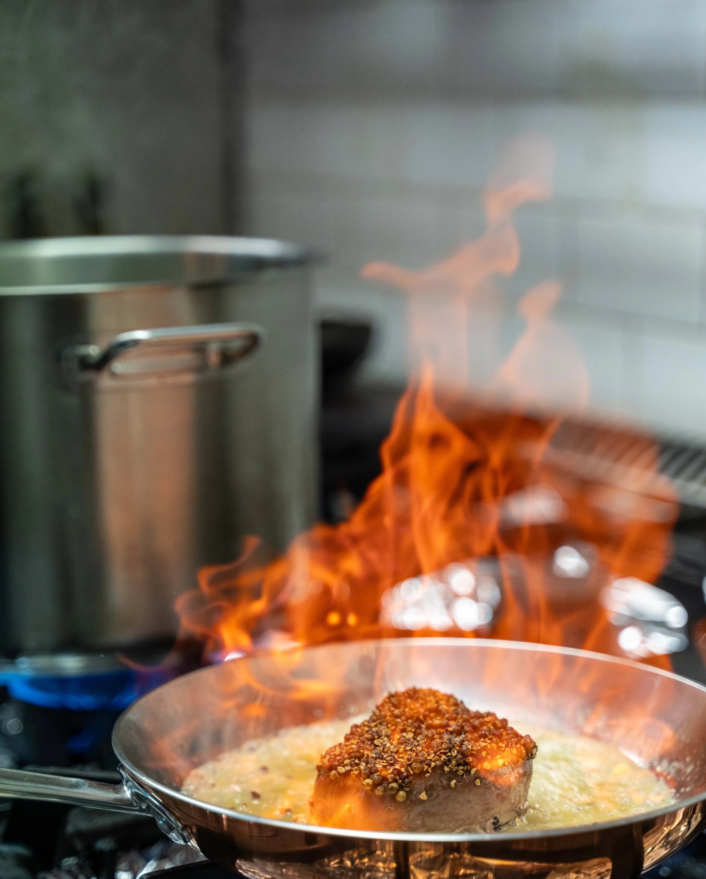 Flambage d'un pavé en poêle dans la cuisine de La Pierre Bleue