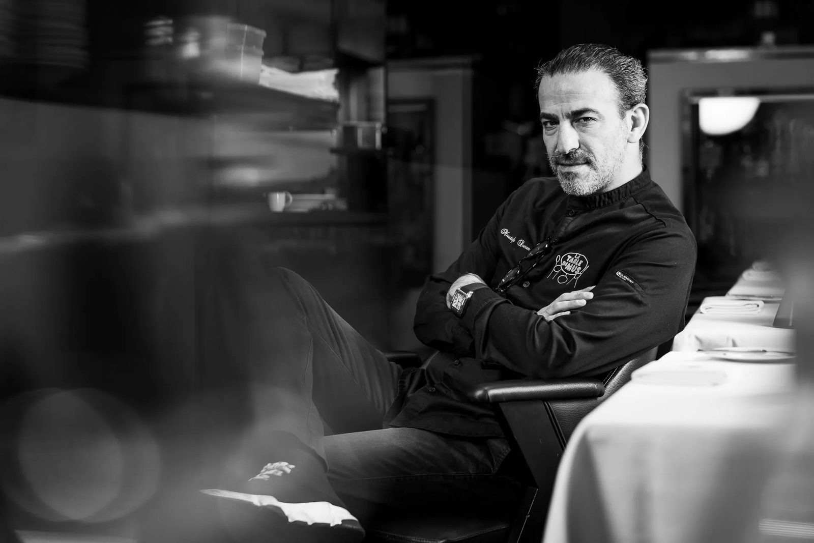 Le chef Mustafa Duran assis en salle, photo en noir et blanc