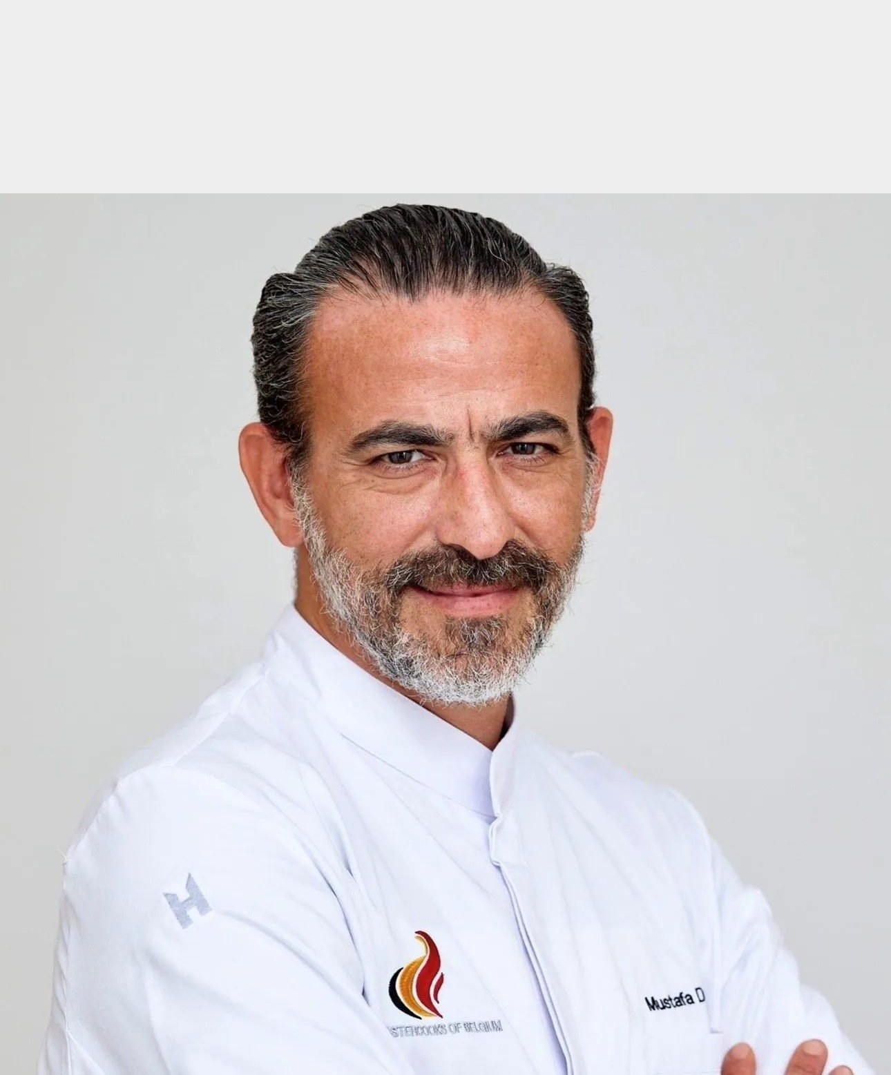 Portrait du chef Mustafa Duran en veste blanche Mastercooks of Belgium