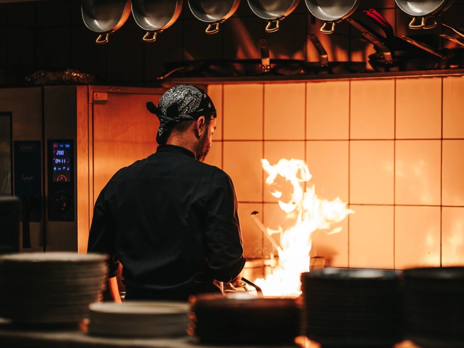 Cuisinier devant les flammes de la cuisine ouverte du Conteur