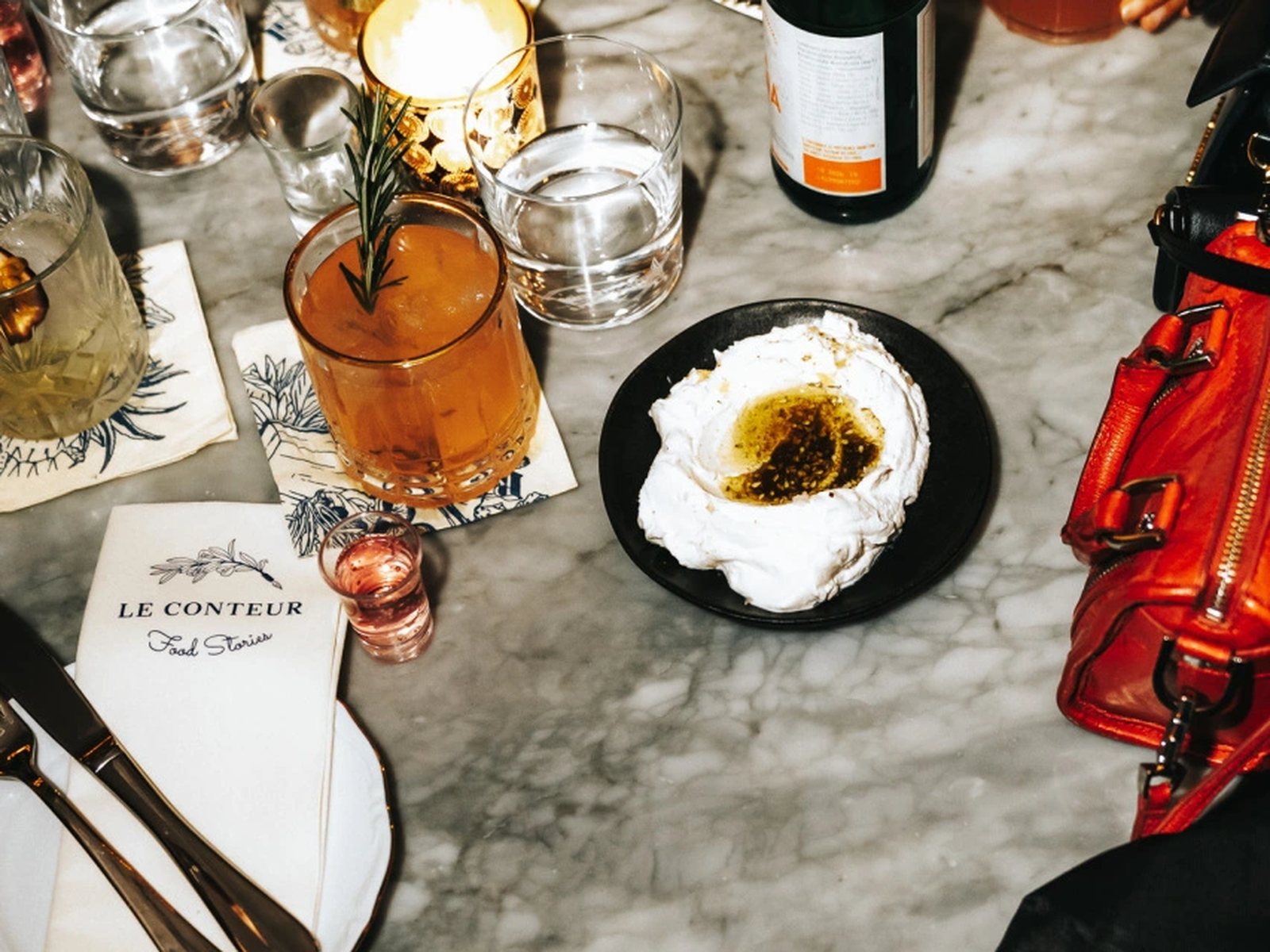 Table en marbre du Conteur avec cocktails, bougie et menu