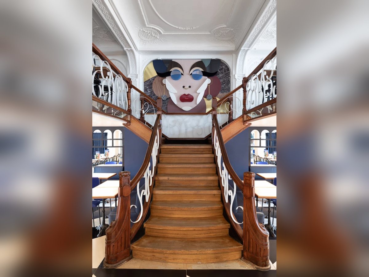 Escalier en bois du Grand Café devant une fresque murale contemporaine
