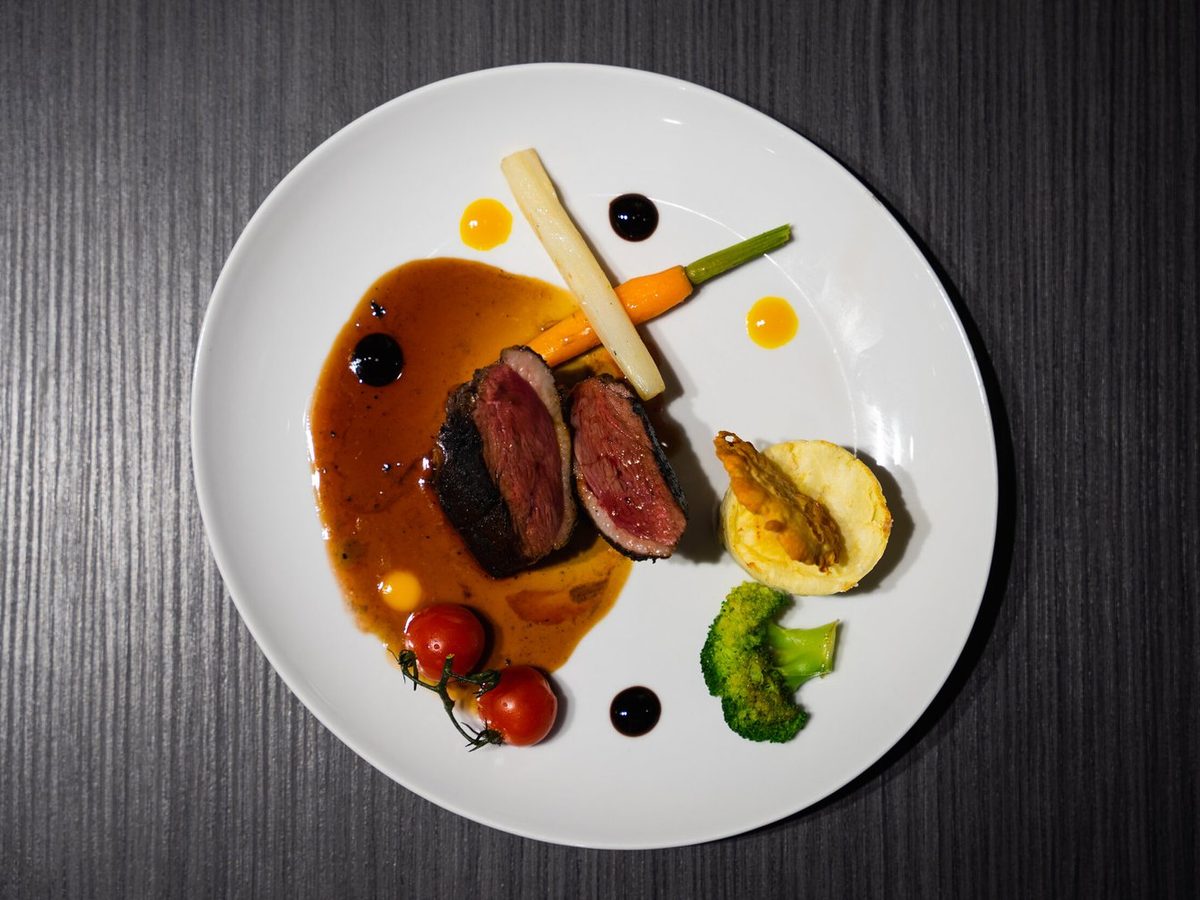 Assiette de viande sauce et légumes dressée au Vintage