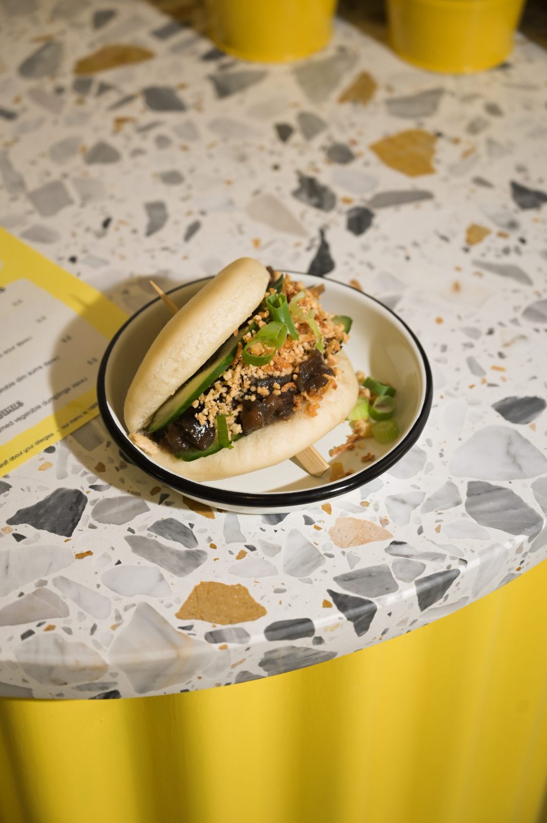 Bao bun garni posé sur une table en terrazzo chez Lil Bao
