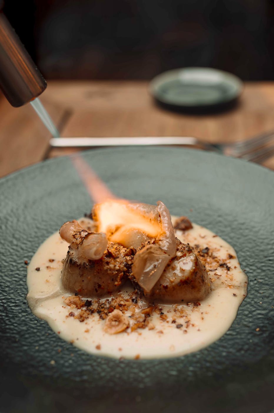 Finition au chalumeau d'un plat chez L'Improbable