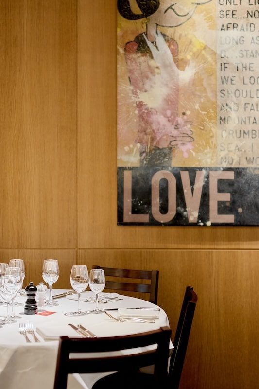 Tableau LOVE et table ronde dressée dans la salle de Lola