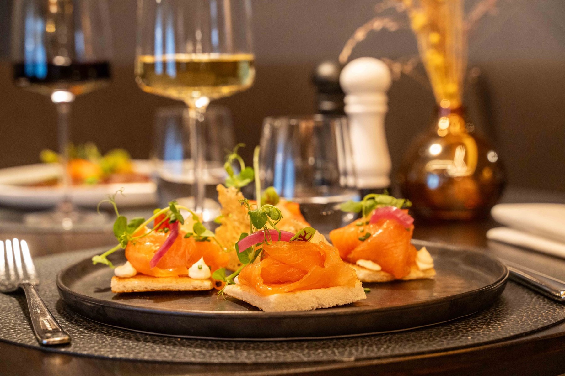 Amuse-bouches au saumon fumé et verres de vin au Loui Restaurant