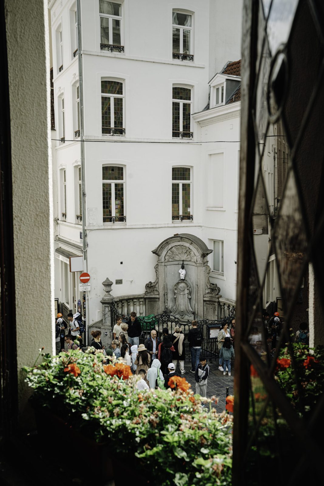 Vue sur la statue du Manneken Pis depuis la fenêtre fleurie du café