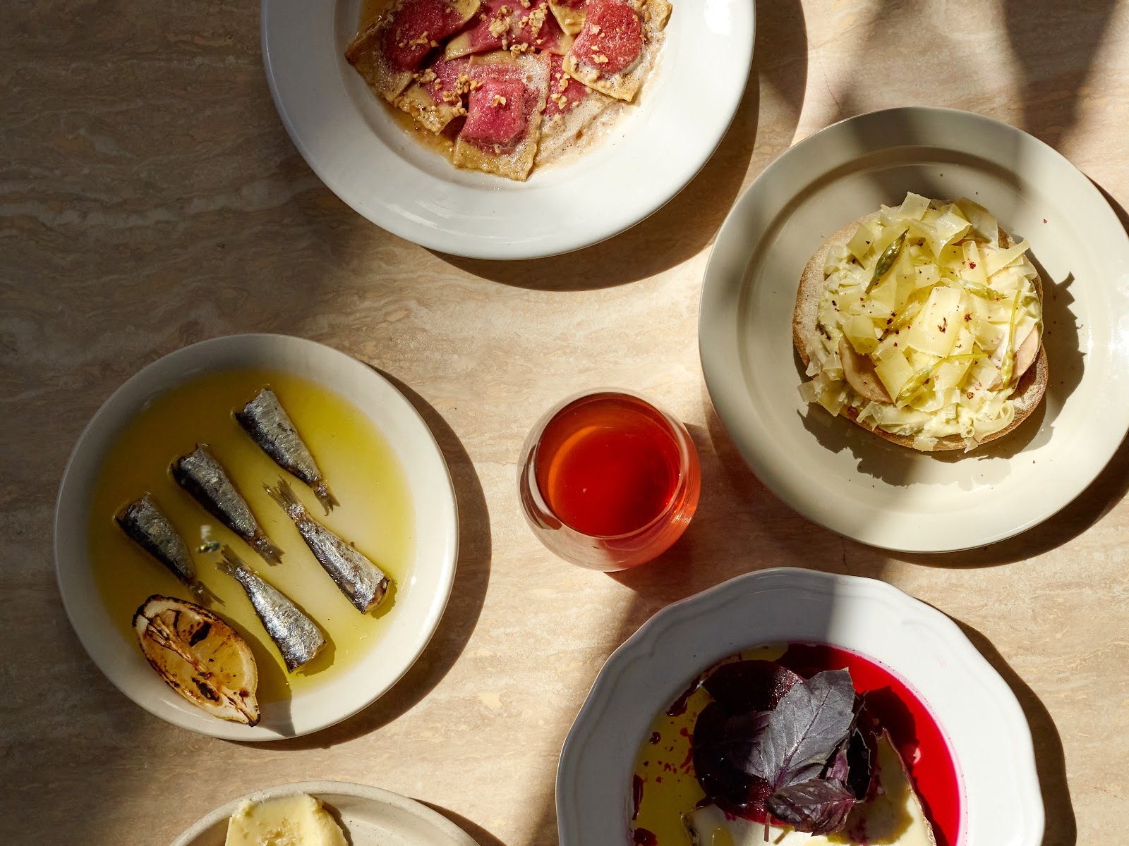 Petites assiettes à partager de Nightshop : sardines à l'huile, tartine au fromage et verre de vin nature