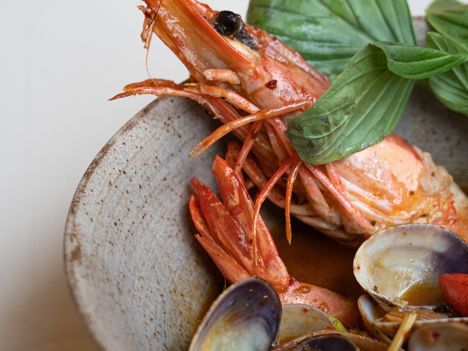 Assiette de crevettes et palourdes au basilic thaï servie chez Old Boy
