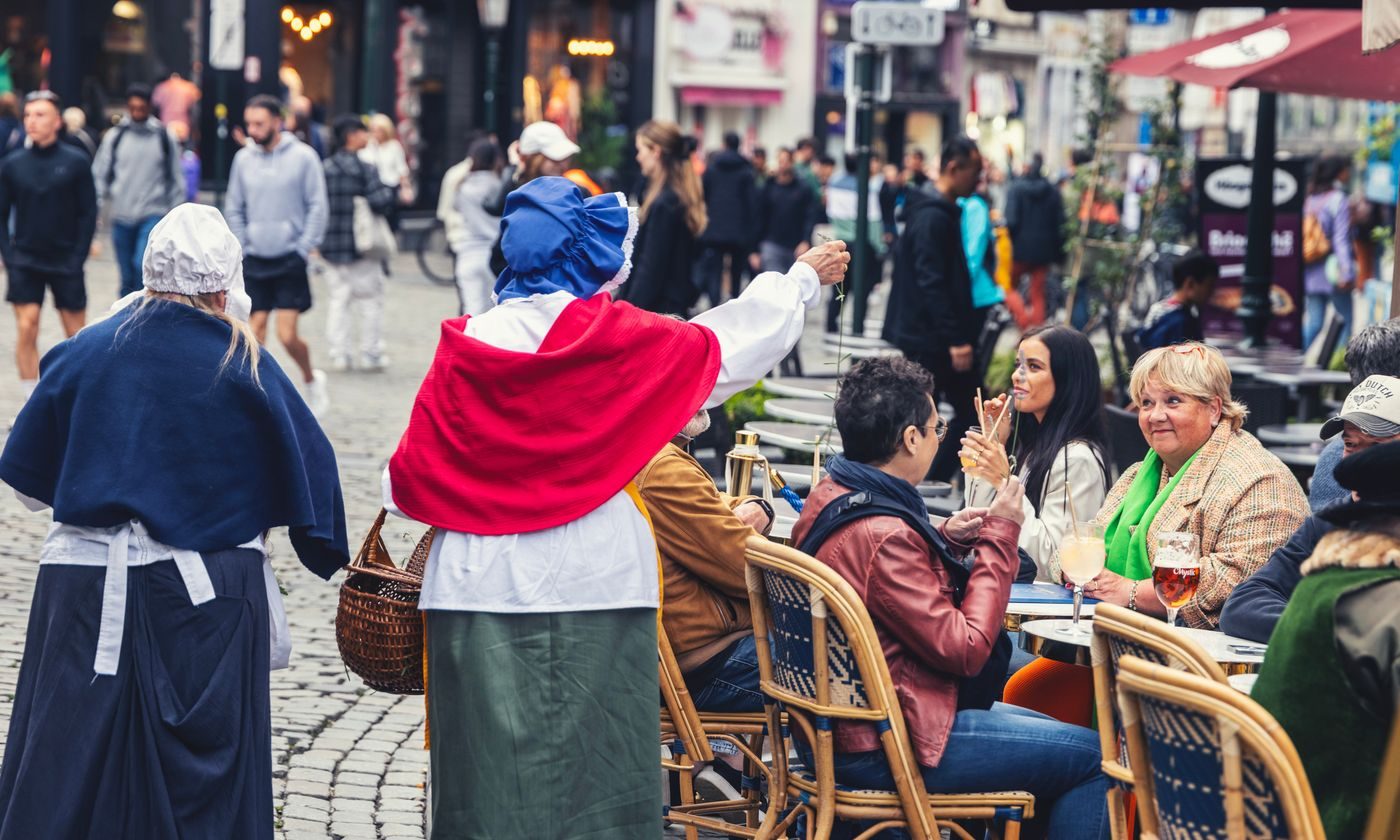Figurants en costume du cortège de l'Ommegang passant devant la terrasse