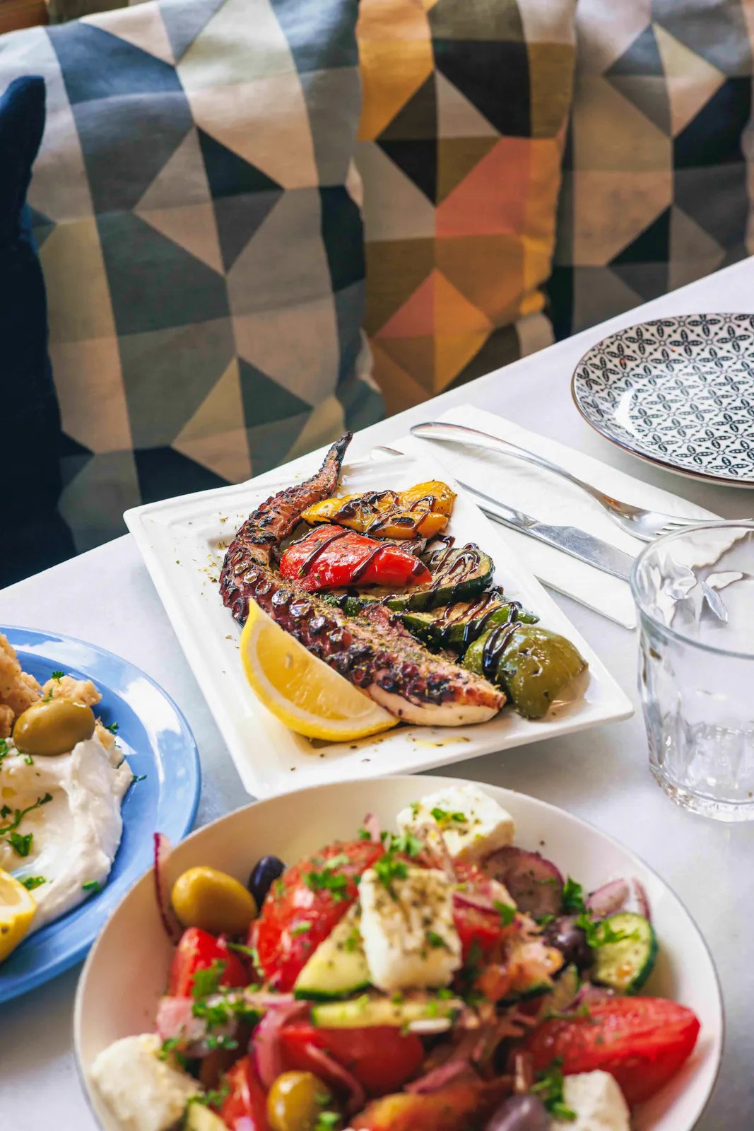 Table dressée chez Opa Wemmel avec poulpe grillé, salade grecque et dips